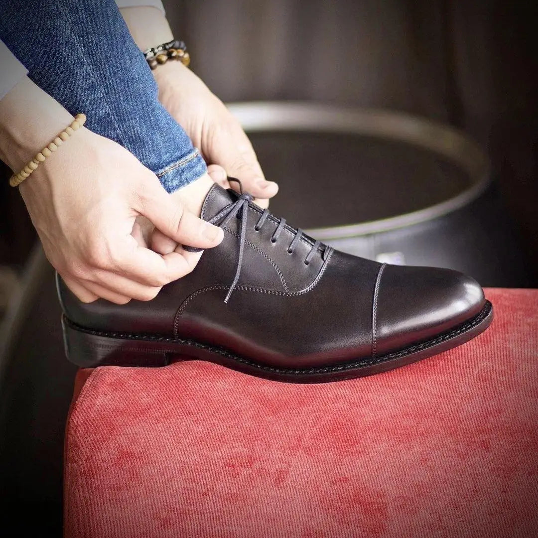 Black leather dress shoe.
