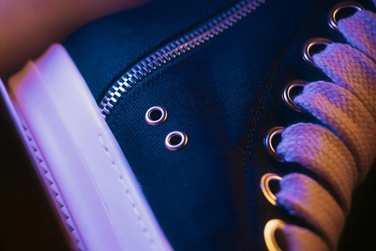 Navy blue high-top sneaker with white sole and metallic eyelets.