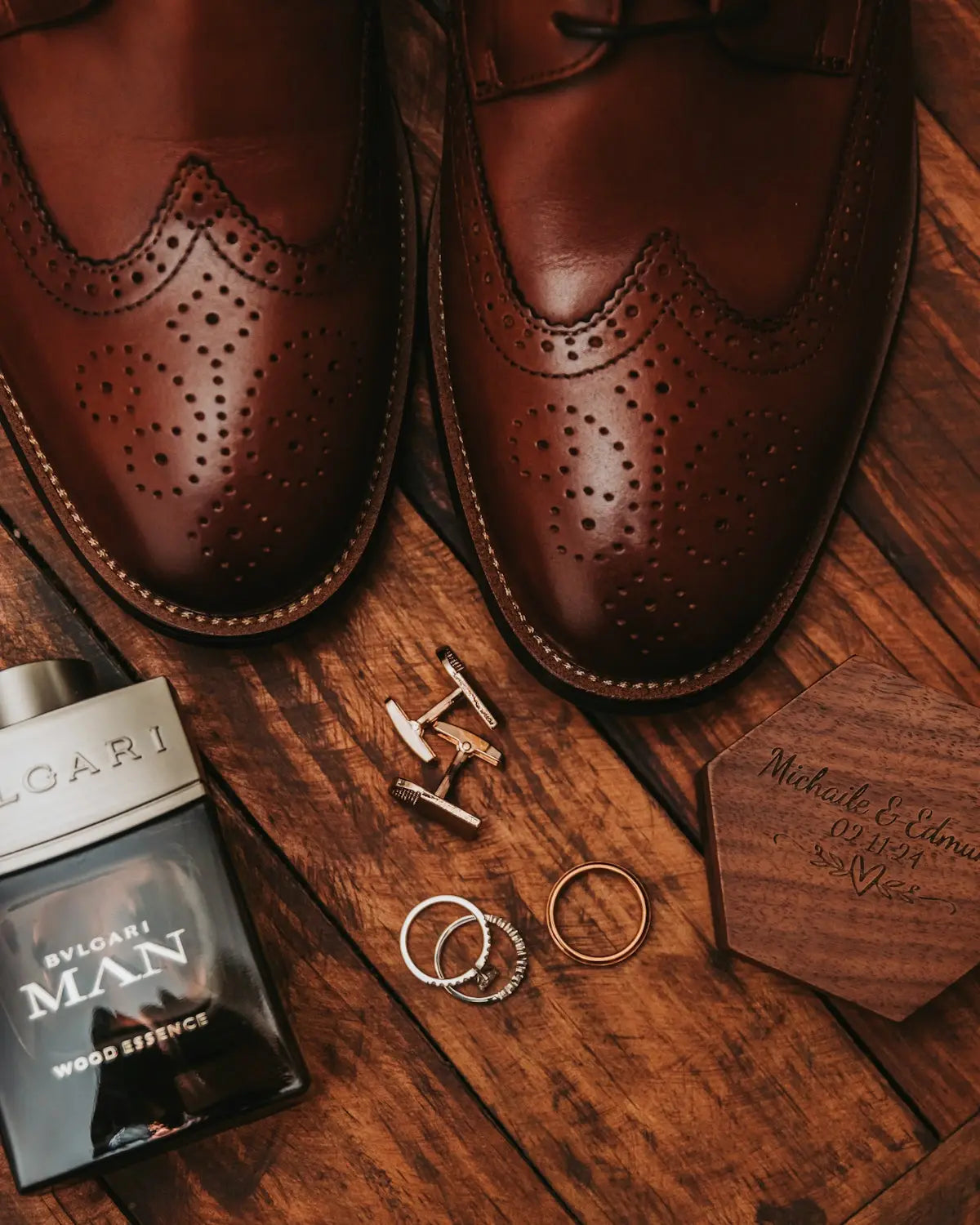 Brown leather wingtip dress shoes with perforated detailing and stitched edges.