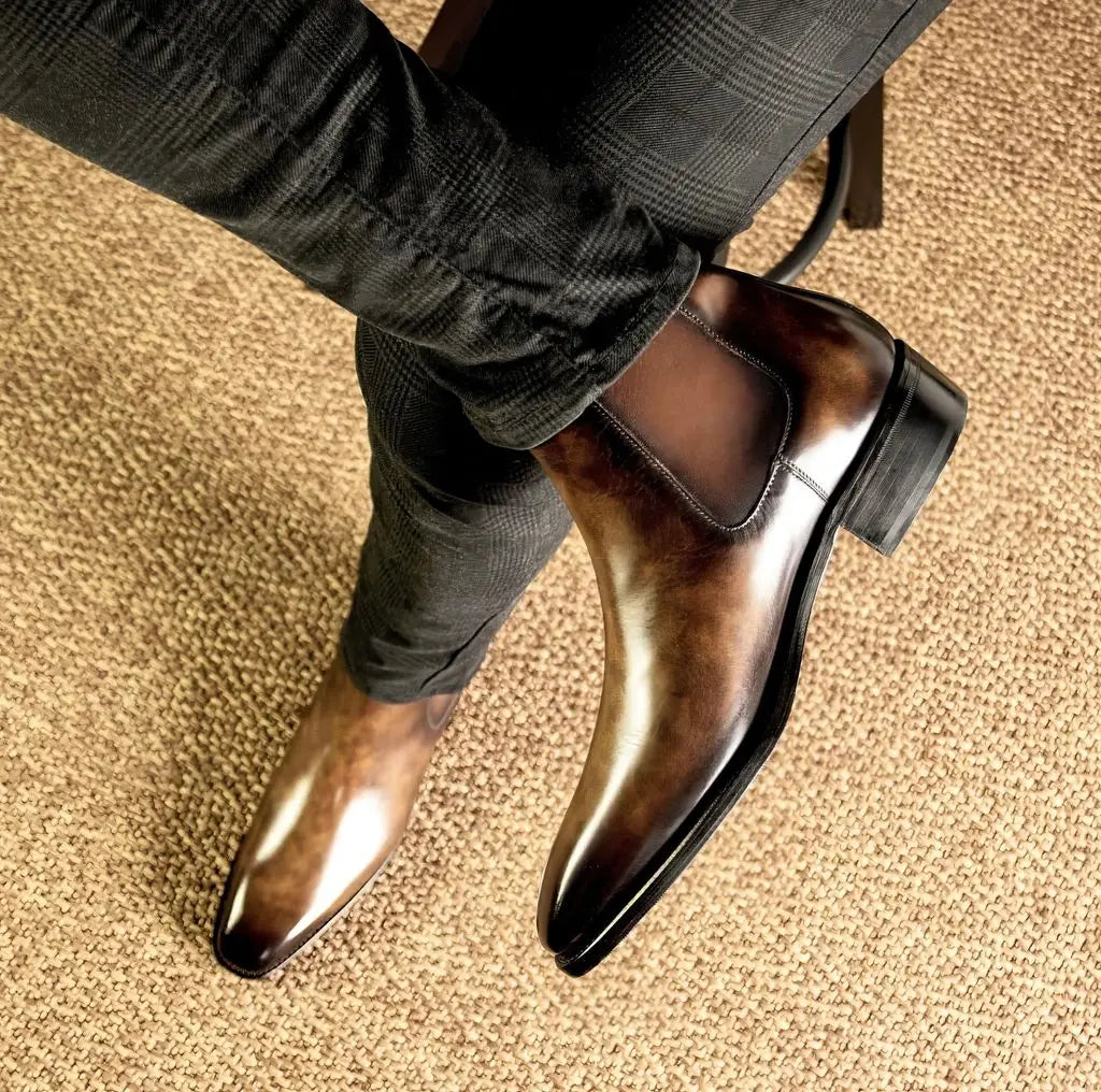 Polished brown leather chelsea boots with a sleek, tapered toe and low block heel.