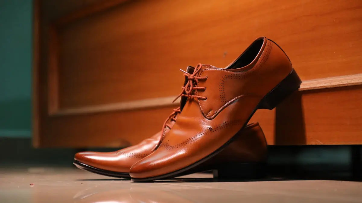 A pair of polished brown leather oxford shoes with matching laces and subtle brogue detailing.