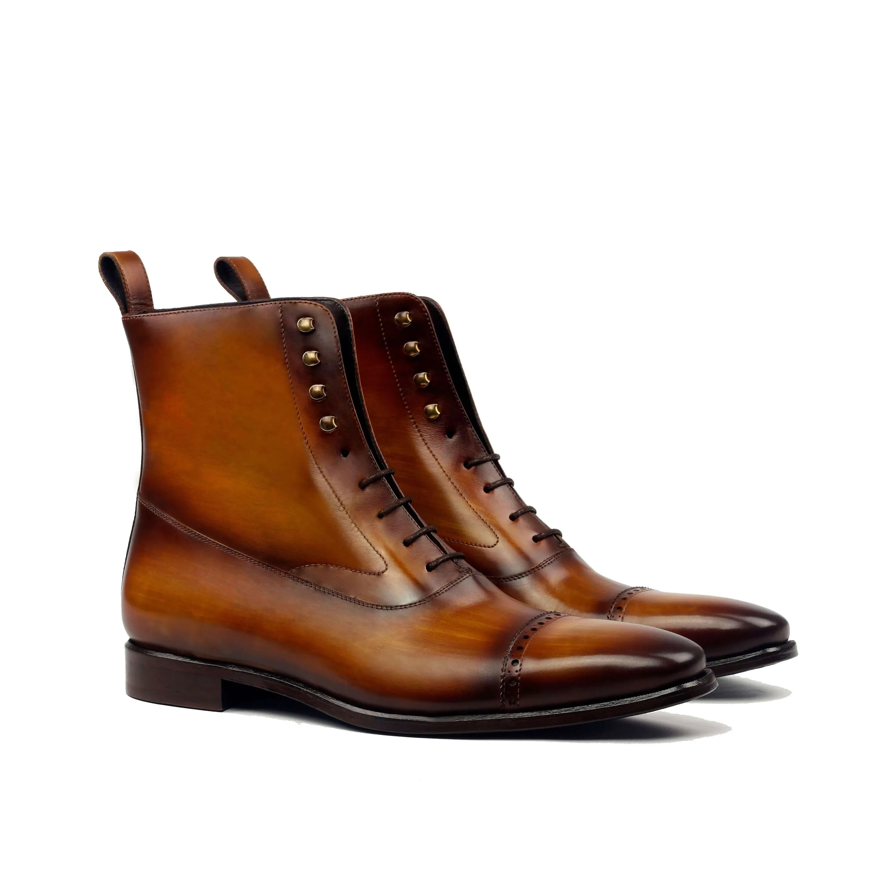 Polished brown leather chukka boots with brass eyelets and a classic cap toe design.
