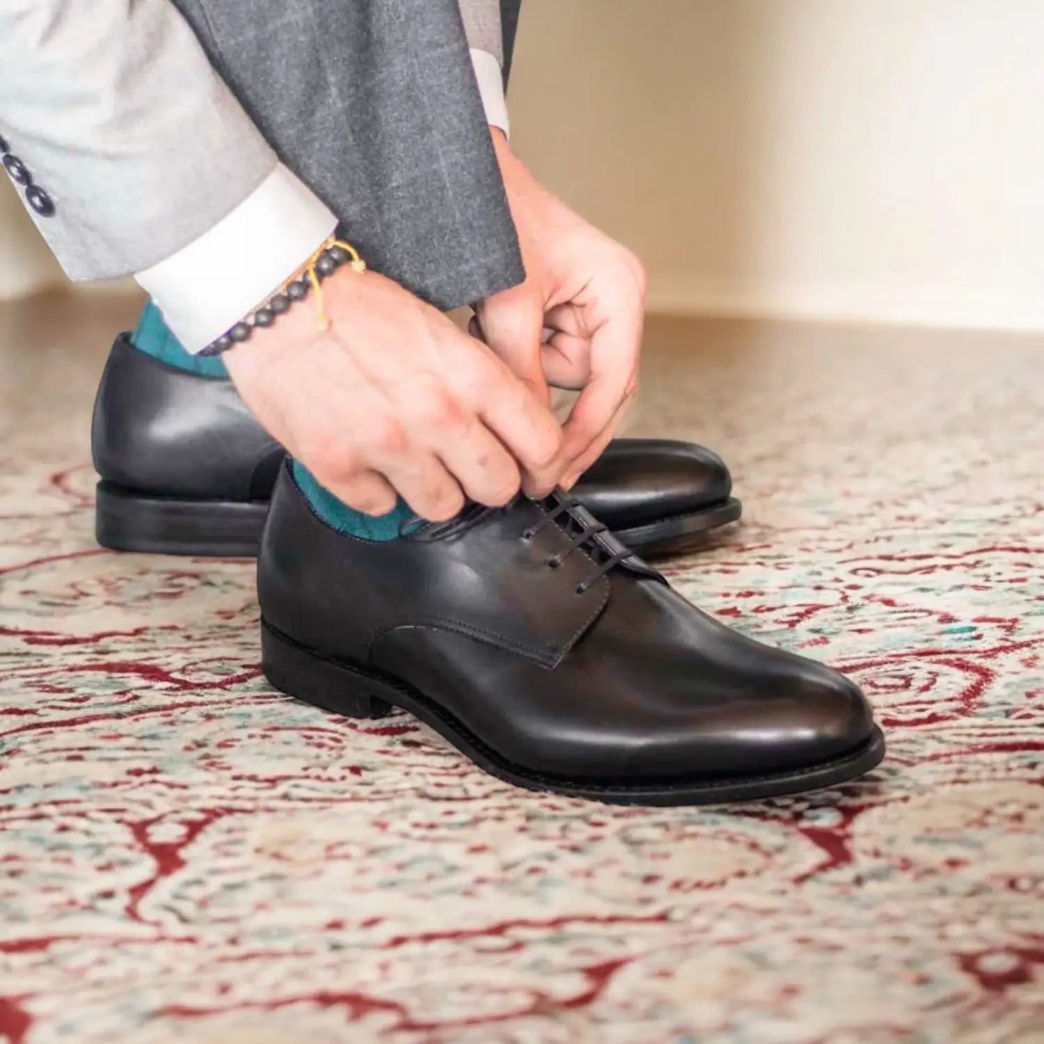 Black leather derby shoes with a polished finish and classic lace-up design.