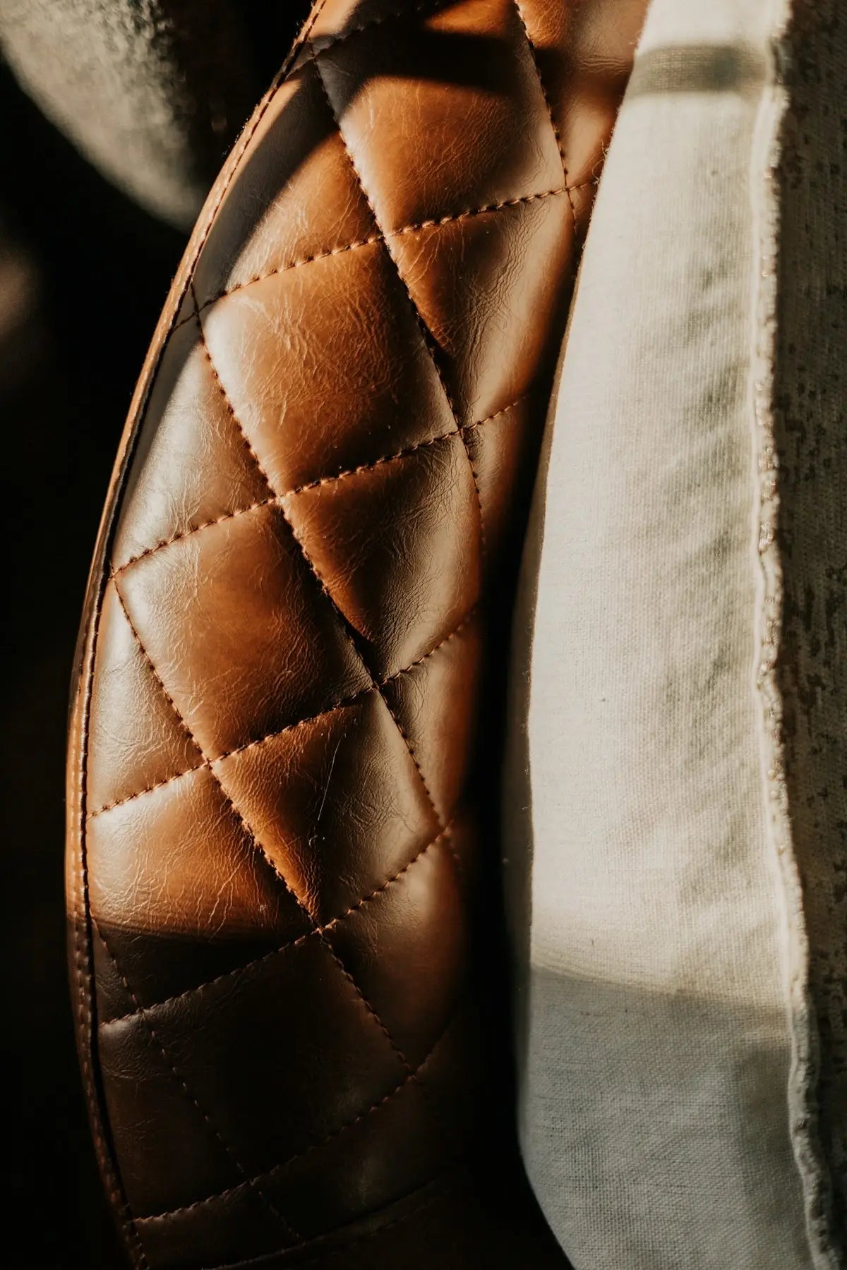 Brown quilted leather seat with diamond-stitched pattern.