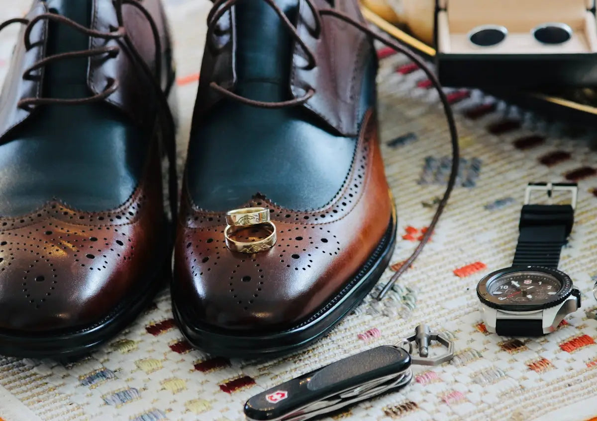Brown leather wingtip oxford shoes with gold accents and brogue detailing.