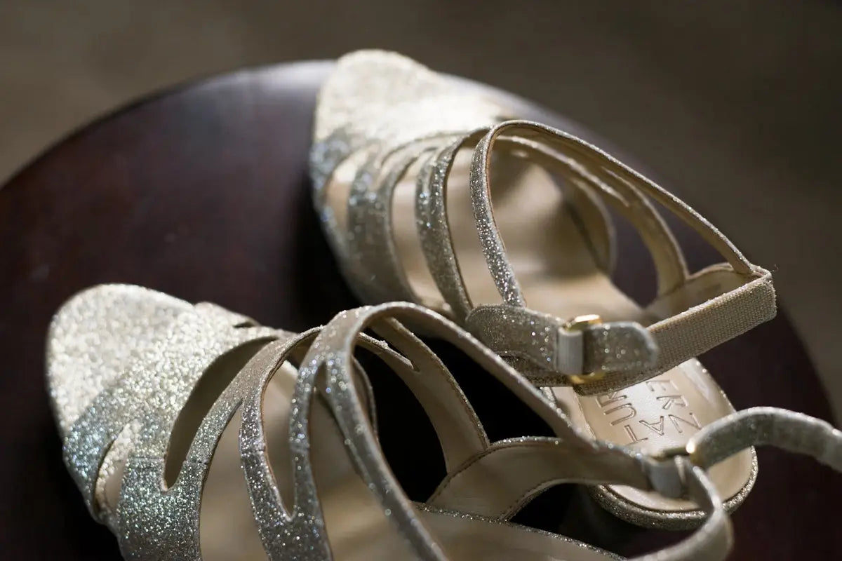 Silver glitter strappy heels with a sleek, open-toe design and adjustable ankle straps.