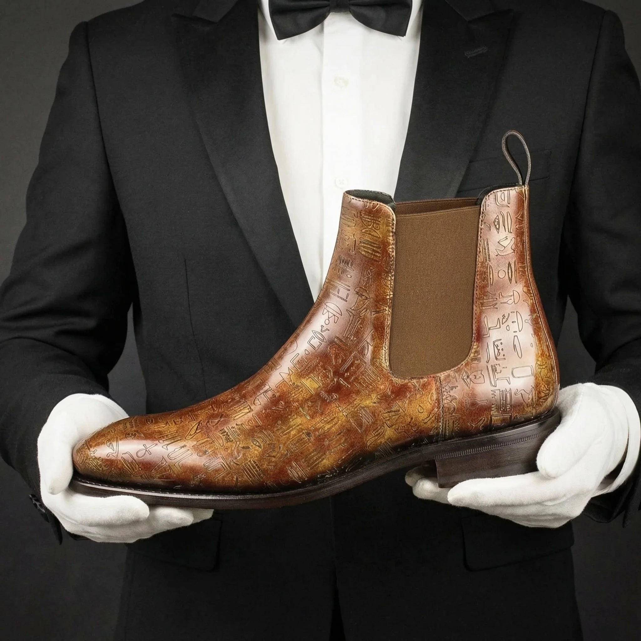 Brown leather patina chelsea boots with embossed ancient script design crafted from italian crust leather goodyear welted