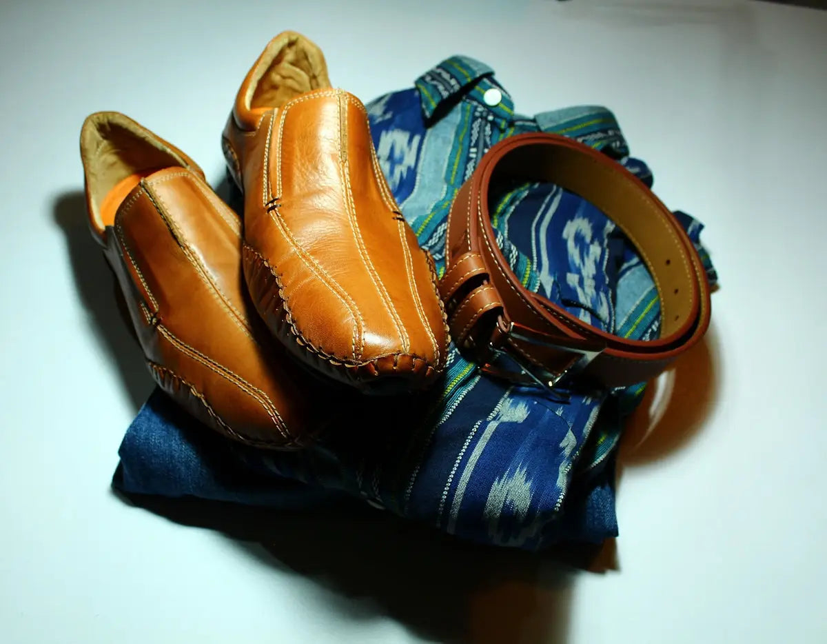 Tan leather loafers with orange accents and green lining.