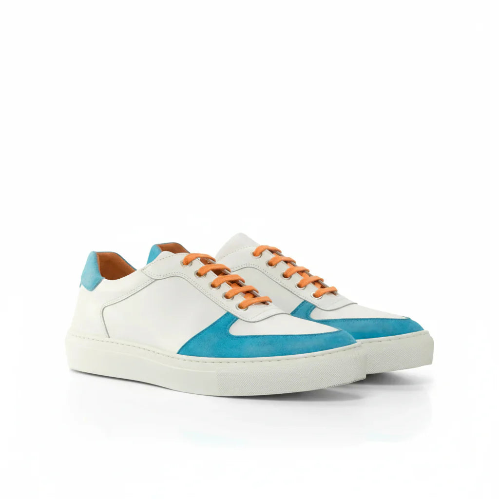 White and turquoise leather sneakers with orange laces.