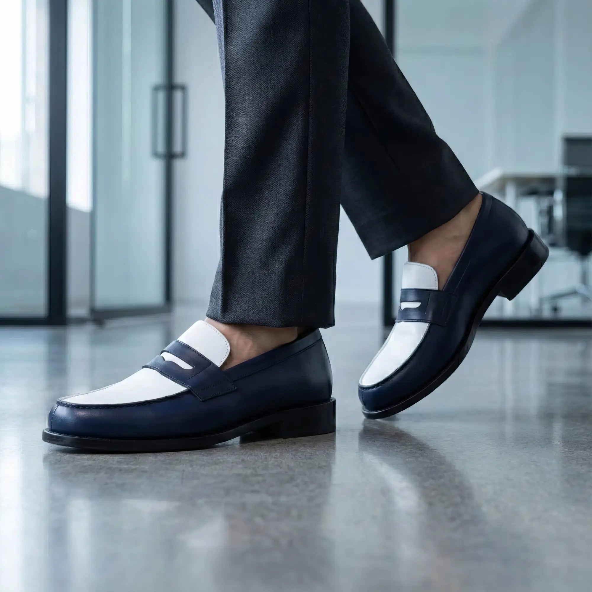 Navy blue and white two-tone leather loafers with a classic penny loafer design