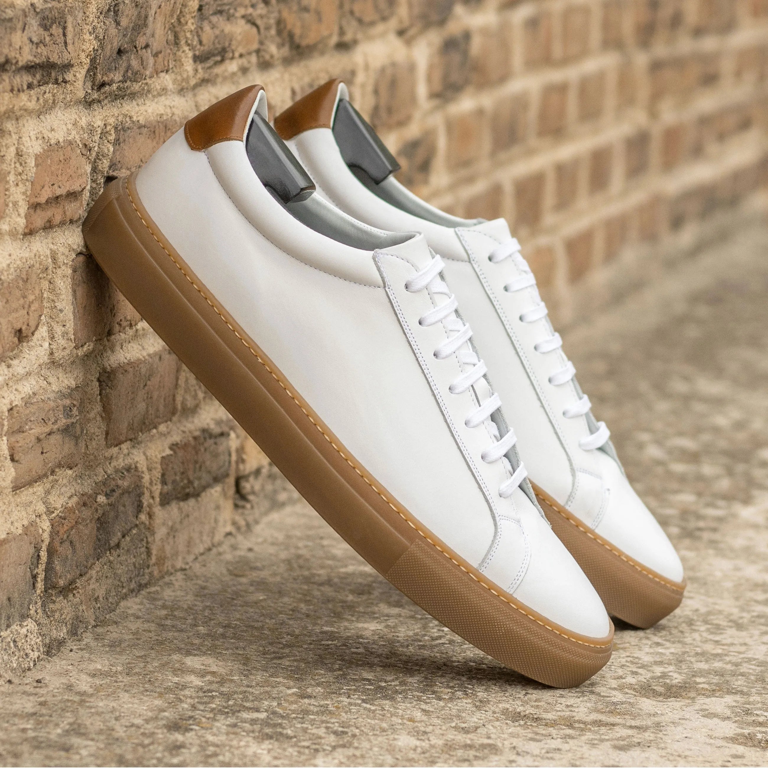 White Conquest Low Kick sneakers with brown soles